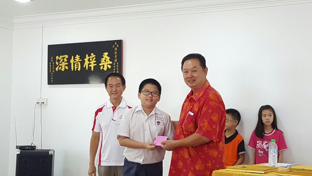 Mr Mah Kin Hock offering reward for student with excellent result.